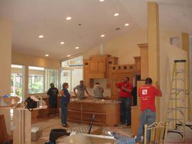 Residential Remodeling. Electricians talking with owner, measuring, and installing lights.